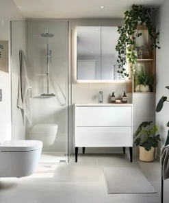 Salle de bain moderne avec meuble-lavabo blanc à tiroirs, miroir lumineux et douche vitrée avec pommeau de pluie – idéale pour rénovation résidentielle.
